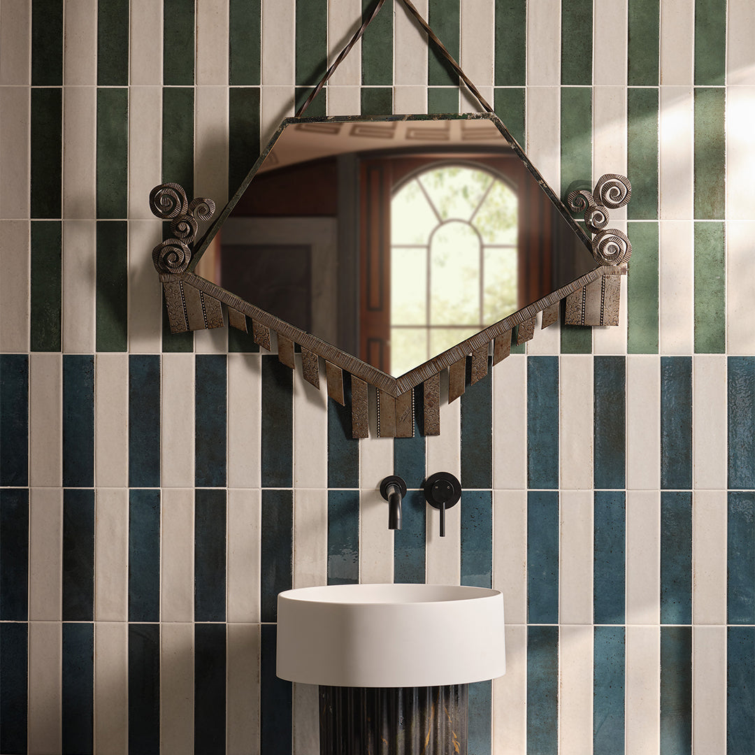 Decorative mirror hanging on a wall with striped tiles