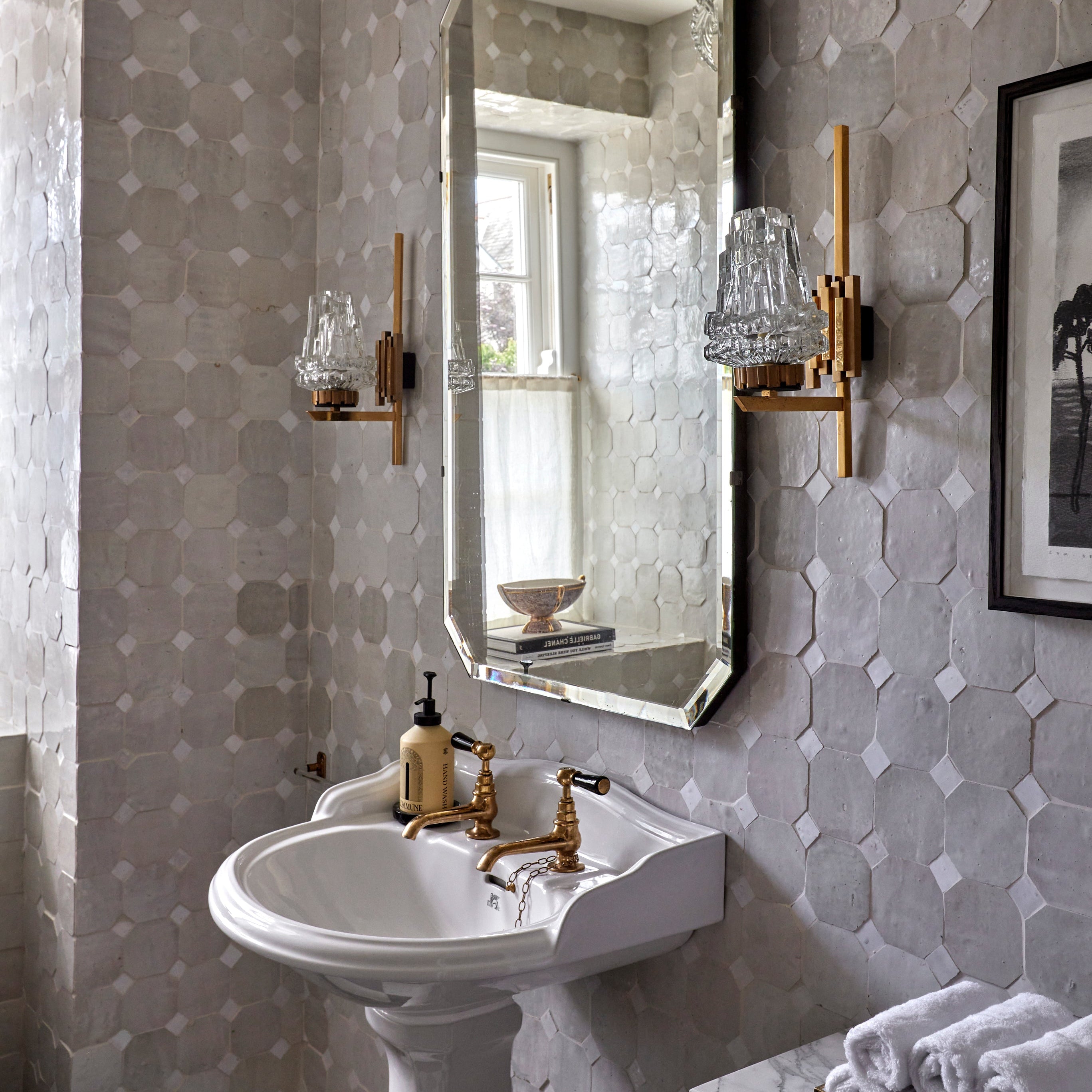 Bathroom with hexagonal tile pattern, sink, and mirror.